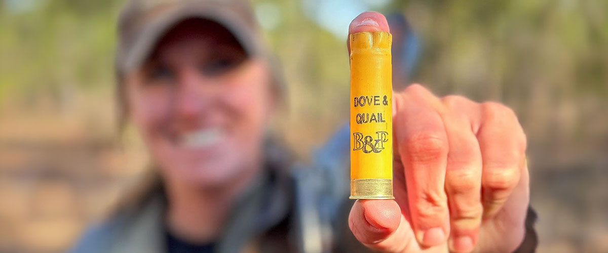 person holding a dove and quail shotshell