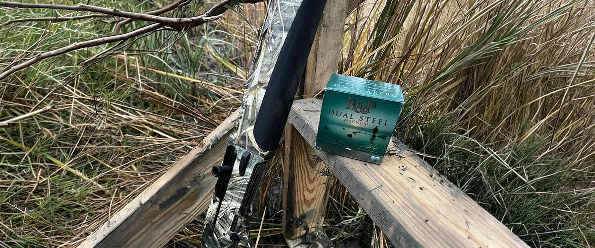 Dual Steel box on a fence post next to a shotgun