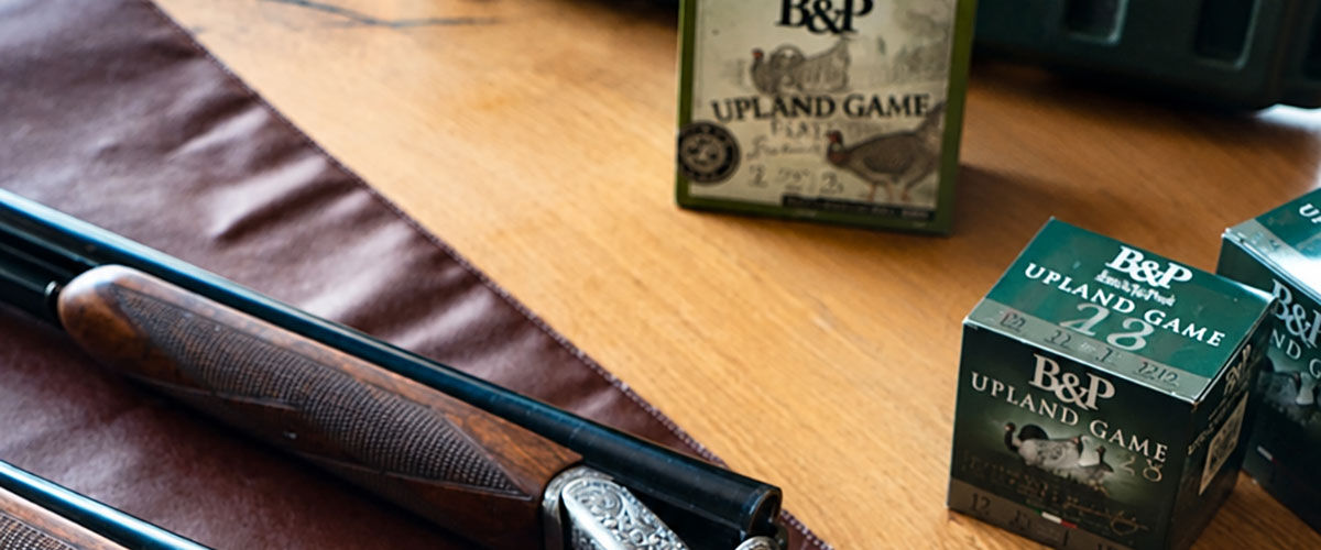 Upland Game and Upland Game Classic boxes next to a shotgun
